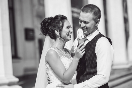 Чорно-біле весільне фото молодят що їдять морозиво з яркими, позитивними емоціямі на обличчі